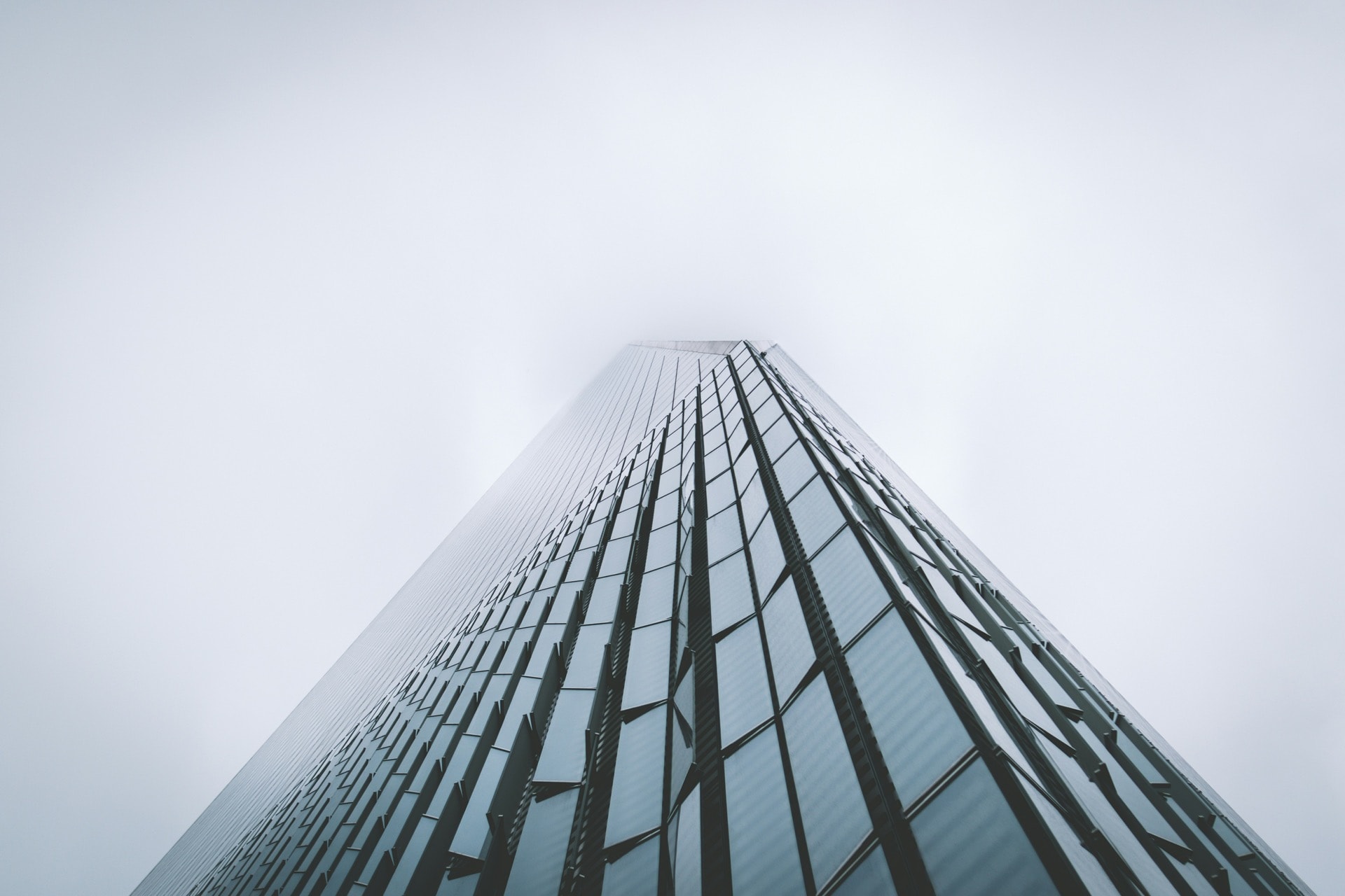 Glass skyscraper looking up into fog